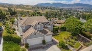 Aerial view of a large, beige house in California with a white garage
