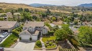 Aerial view of a suburban neighborhood with large houses and green yards in California.