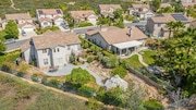 Aerial view of a neighborhood with two large, beige houses in California.