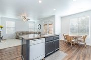 Kitchen and living area with wood floors, and a central island in California.
