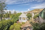 A white gazebo with rolling hills and houses in the background in Califronia.