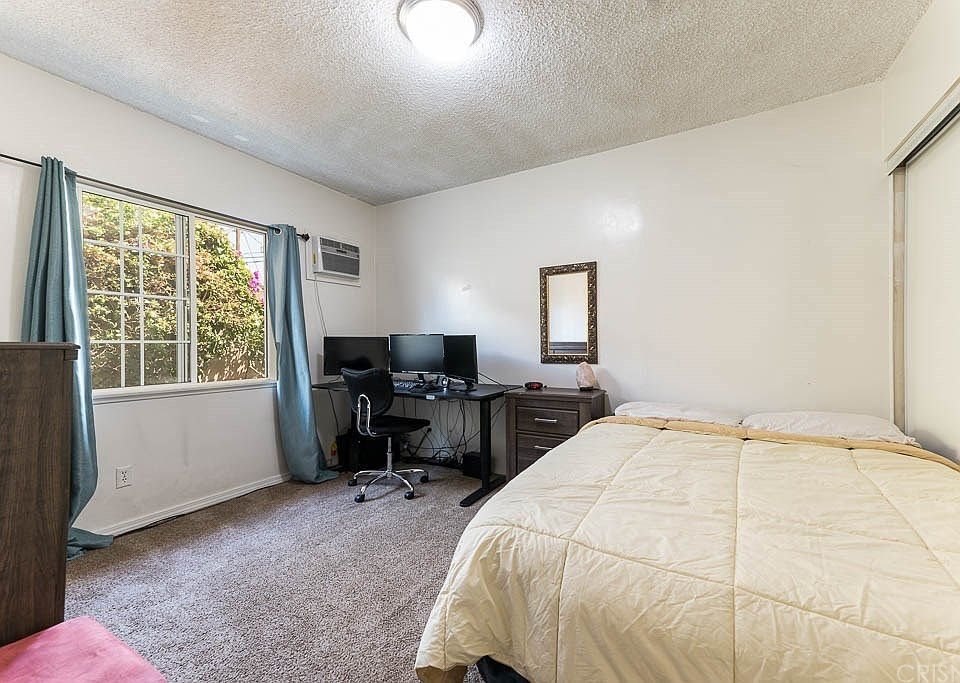 Bedroom in California with bed and computer setup.