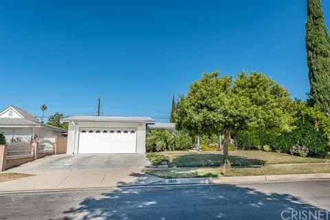 House in California with a white garage, driveway, and a front lawn