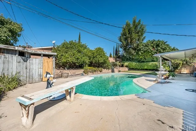 Backyard with a pool, diving board and shed in California.