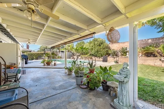 Covered patio in California with ceiling fans, plants, and a pool