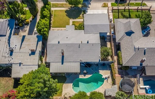Aerial view of a neighborhood houses in California with a gray roof, a backyard pool.