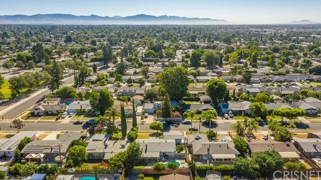 Aerial view of a neighborhood in California with tree-lined streets and houses.