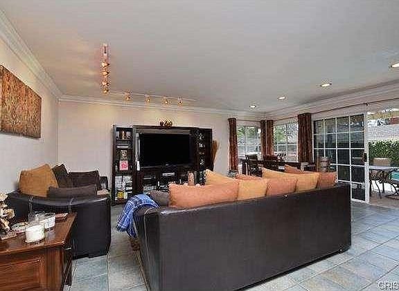 Living room in California with sofas and colorful cushions and a TV.