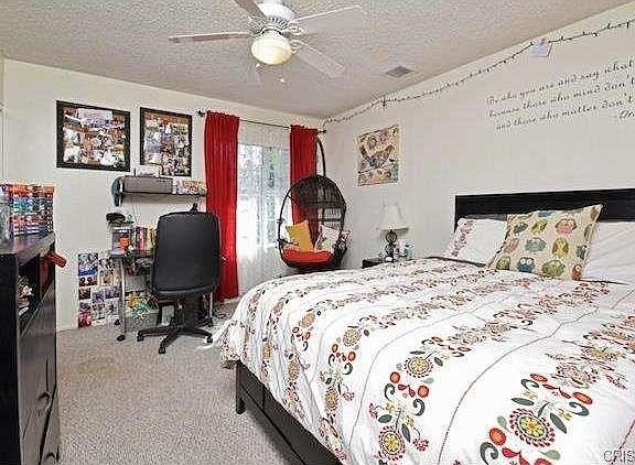 Bedroom in California with patterned bedding, desk and chair.