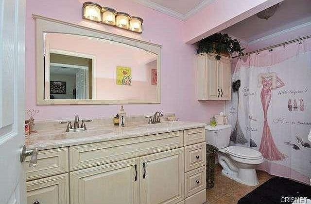 Bathroom in California with a marble-topped vanity, mirror, and a shower curtain.