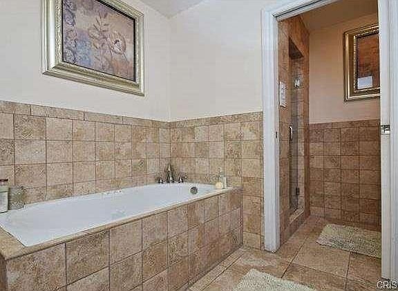 Luxury bathroom in California with large white bathtub and a walk-in shower