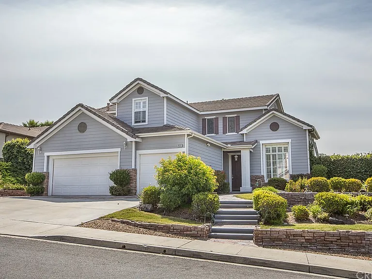 A modern two-story gray house with white trim, featuring a two-car garage in California.